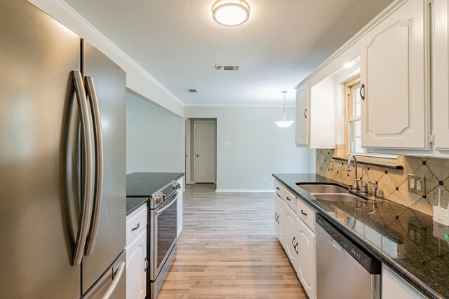 kitchen with sink, light wood-type flooring, stainless steel appliances, and white cabinetry