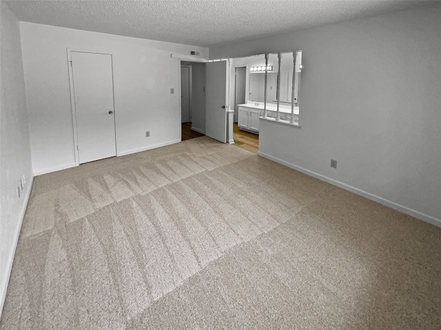 carpeted spare room featuring a textured ceiling