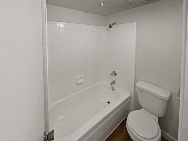 bathroom featuring tiled shower / bath and toilet