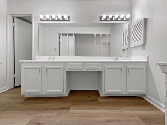 bathroom featuring hardwood / wood-style flooring and dual bowl vanity