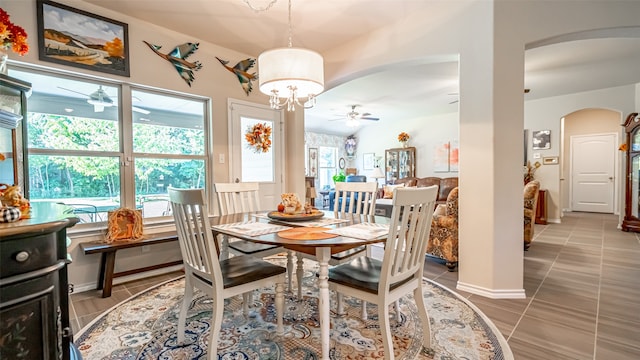 dining space with ceiling fan with notable chandelier and tile patterned floors