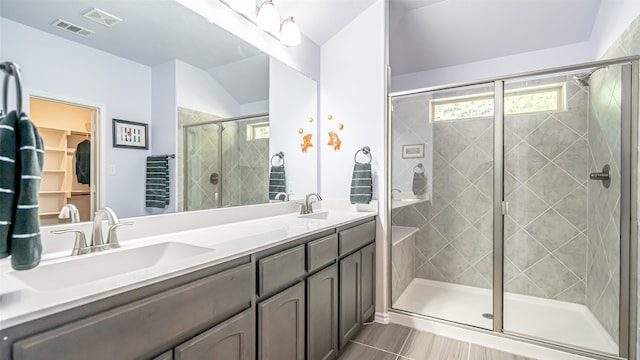 bathroom featuring vaulted ceiling, a shower with shower door, and vanity