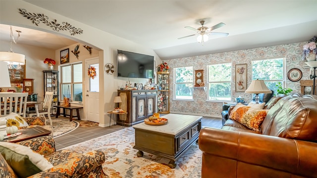 tiled living room with ceiling fan and lofted ceiling