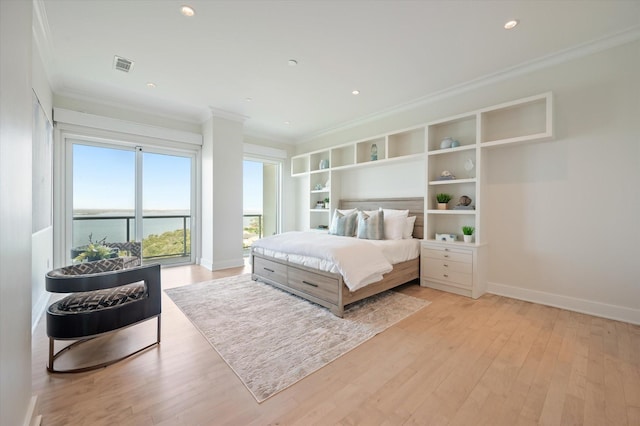 bedroom featuring crown molding, light hardwood / wood-style flooring, a water view, and access to outside