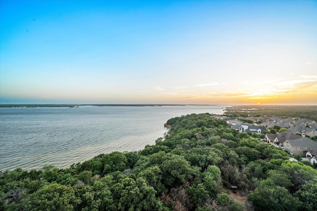 aerial view at dusk featuring a water view