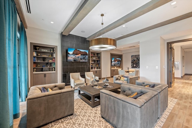 living room with beam ceiling, built in features, and light hardwood / wood-style floors