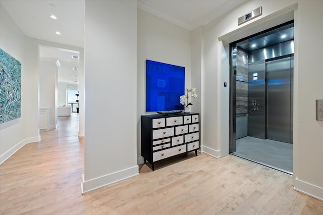 hallway with light hardwood / wood-style floors and elevator