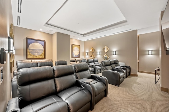 carpeted home theater room with a tray ceiling