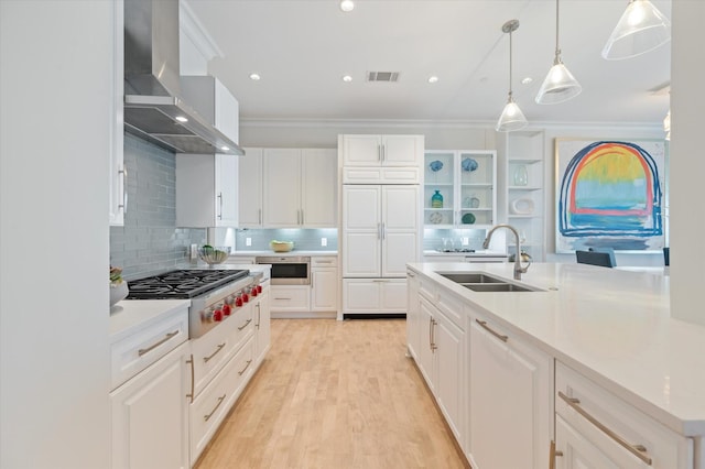 kitchen featuring white cabinetry, sink, and wall chimney exhaust hood