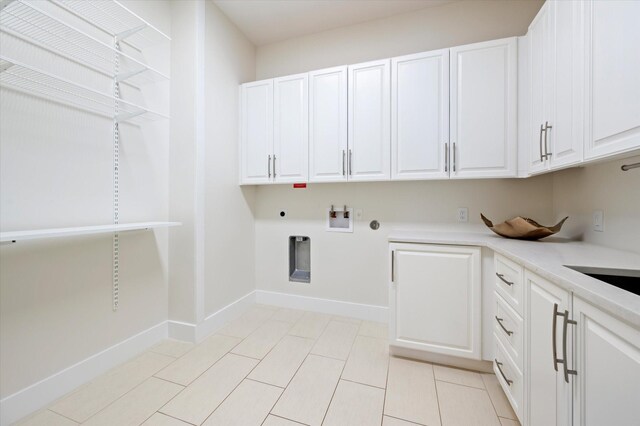 laundry area with cabinets, light tile patterned floors, washer hookup, hookup for an electric dryer, and hookup for a gas dryer