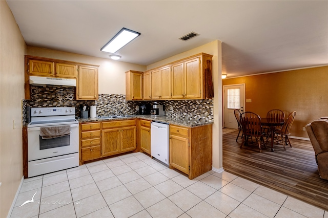 kitchen with sink, light wood-type flooring, white appliances, and backsplash