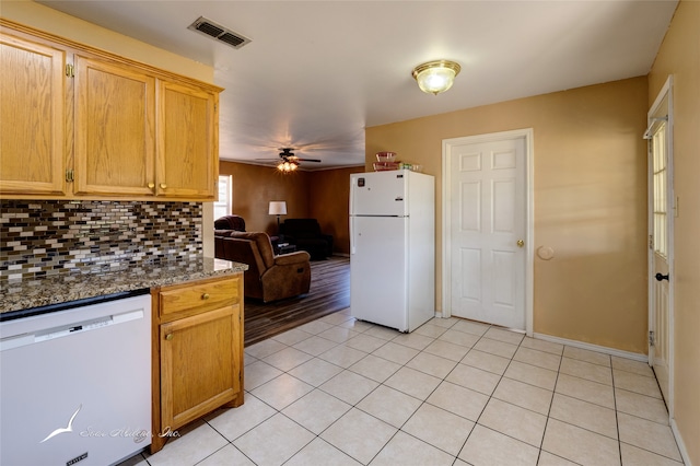 kitchen featuring ceiling fan, decorative backsplash, white appliances, dark stone countertops, and light hardwood / wood-style flooring