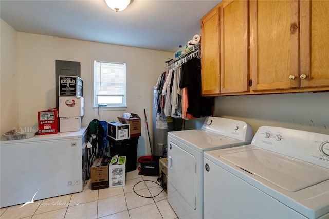 washroom featuring light tile patterned flooring, cabinets, and independent washer and dryer