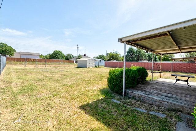 view of yard featuring a wooden deck and a storage shed