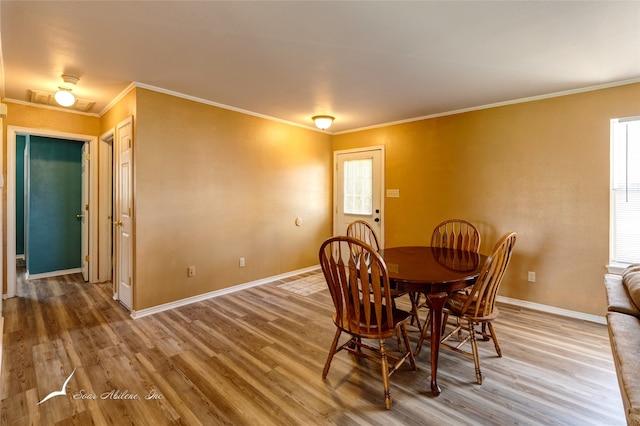 dining space featuring ornamental molding and hardwood / wood-style floors