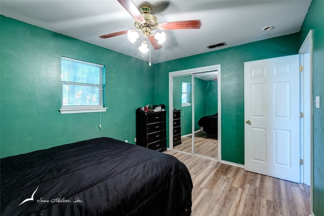 bedroom featuring light hardwood / wood-style flooring, ceiling fan, and a closet