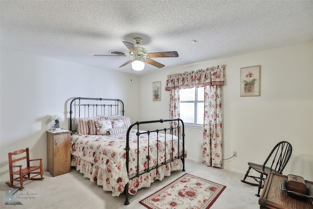 carpeted bedroom featuring a textured ceiling and ceiling fan