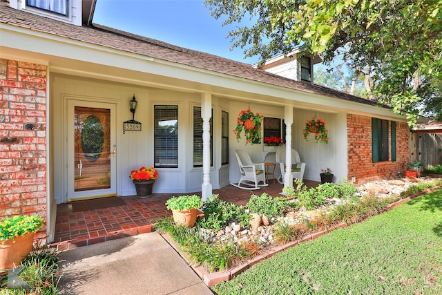 view of exterior entry featuring covered porch