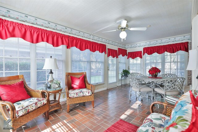 sunroom / solarium featuring a healthy amount of sunlight and ceiling fan