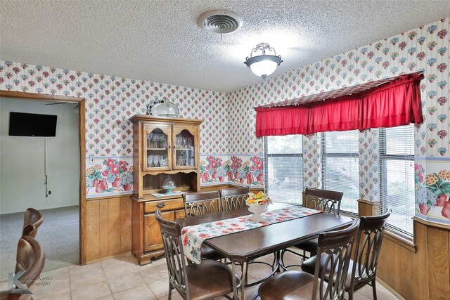 dining space featuring light tile patterned flooring and a textured ceiling