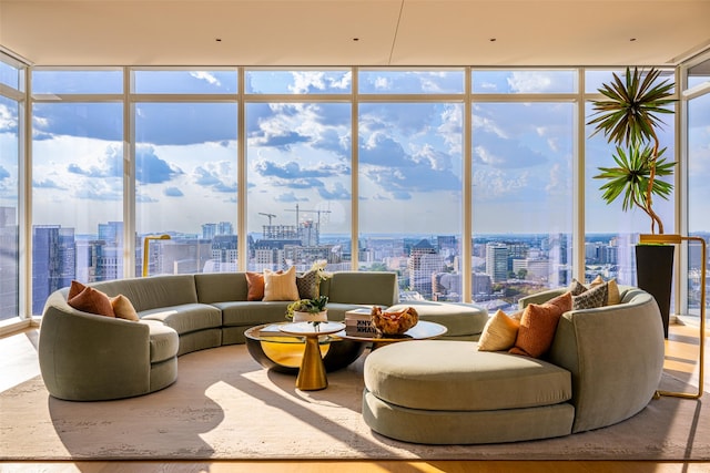 living room with hardwood / wood-style flooring, a healthy amount of sunlight, and a wall of windows