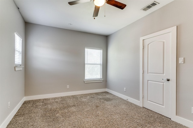 carpeted spare room featuring ceiling fan