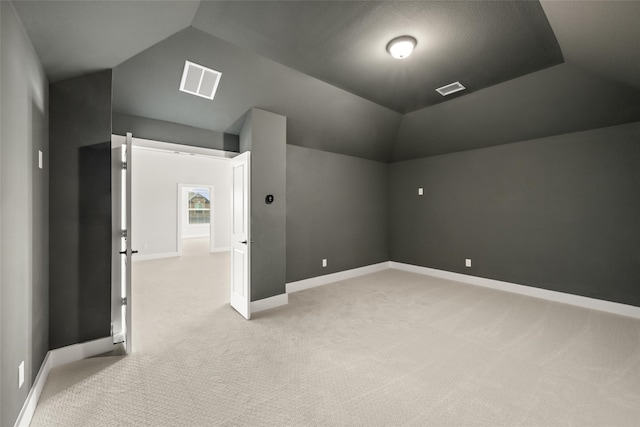 additional living space with light carpet and vaulted ceiling