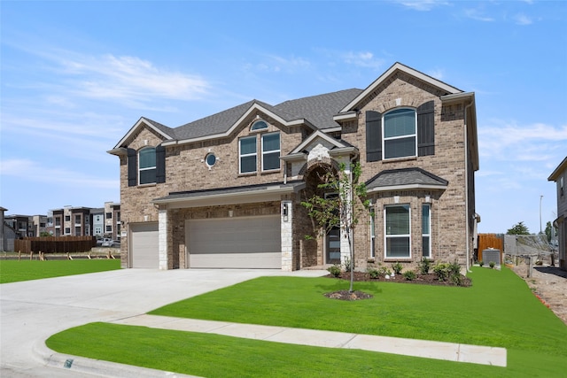 craftsman house with a front yard, a garage, and central AC unit