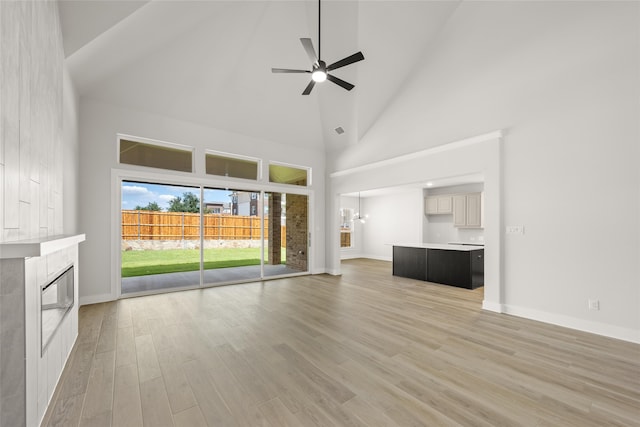 unfurnished living room featuring high vaulted ceiling, light hardwood / wood-style floors, and ceiling fan