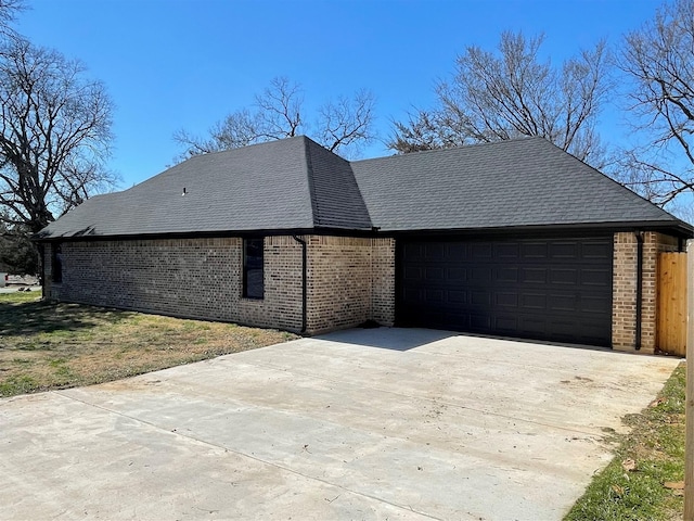 view of side of home featuring concrete driveway, brick siding, and an attached garage