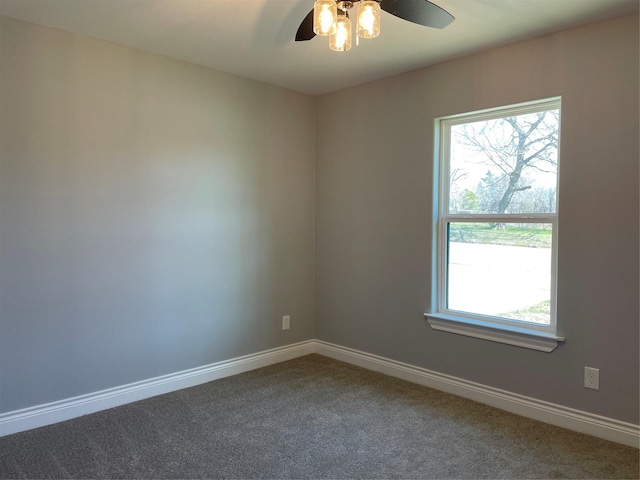 carpeted empty room featuring a healthy amount of sunlight, ceiling fan, and baseboards