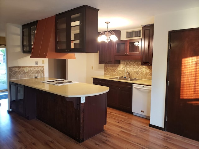 kitchen with white appliances, sink, hanging light fixtures, kitchen peninsula, and a breakfast bar area