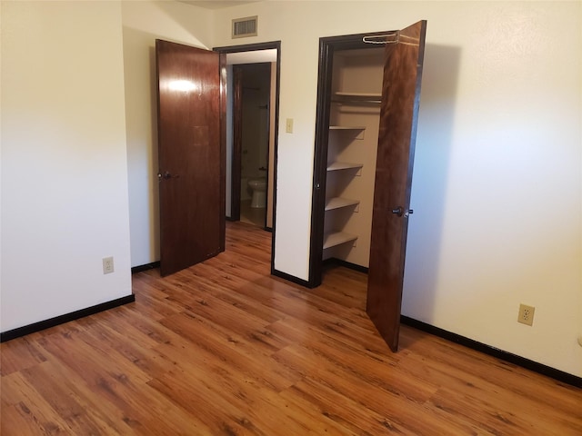 unfurnished bedroom with hardwood / wood-style flooring