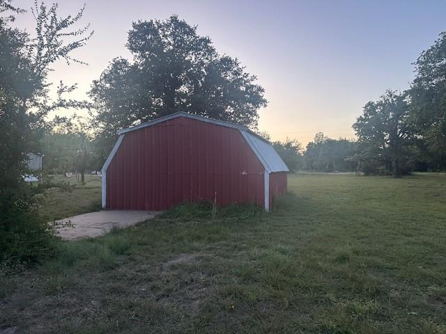 outdoor structure at dusk with a yard