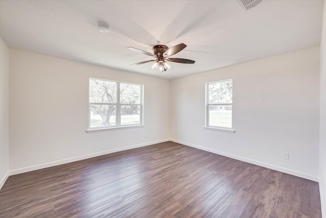 spare room with dark wood-type flooring and ceiling fan