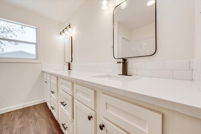 bathroom with backsplash, hardwood / wood-style floors, and vanity