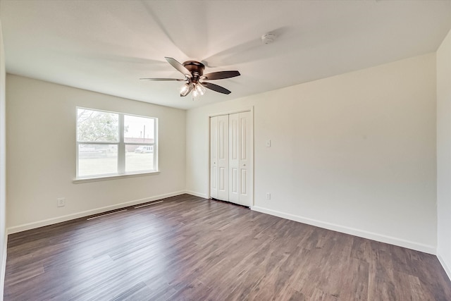 unfurnished bedroom featuring dark hardwood / wood-style flooring, a closet, and ceiling fan