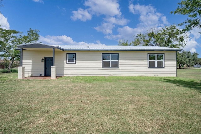 rear view of property featuring a lawn