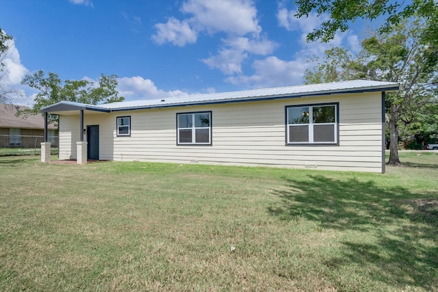 rear view of property featuring a lawn