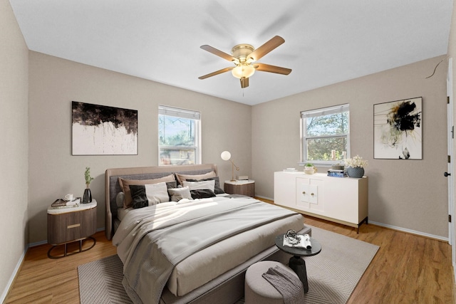 bedroom with multiple windows, ceiling fan, and light hardwood / wood-style floors