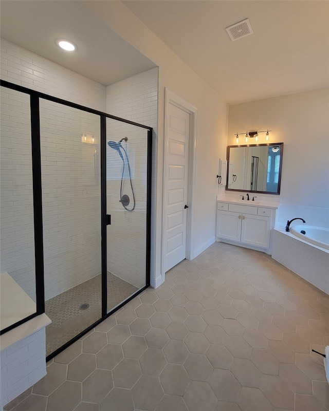 bathroom with tile patterned flooring, independent shower and bath, and vanity