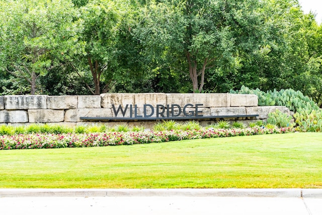 community sign featuring a yard