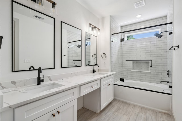 bathroom with dual vanity and shower / bath combination with glass door