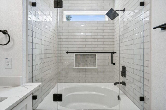 bathroom featuring vanity and shower / bath combination with glass door