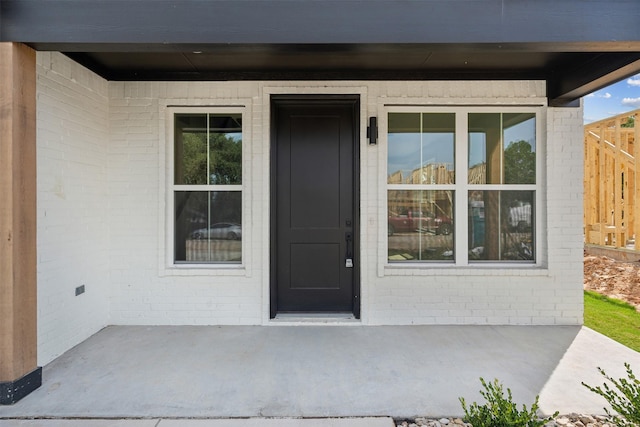 view of exterior entry featuring a patio