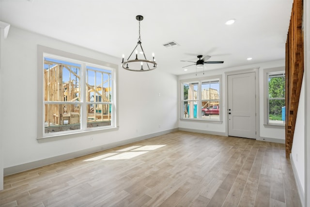 interior space with light wood-type flooring and ceiling fan with notable chandelier