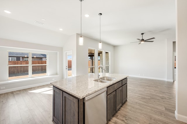 kitchen with decorative light fixtures, dishwasher, sink, light stone countertops, and dark brown cabinets