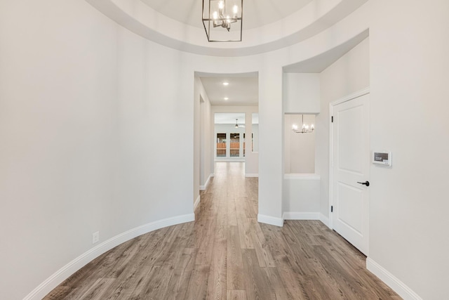 hall featuring hardwood / wood-style floors and a notable chandelier