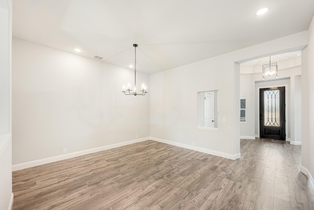 entryway featuring an inviting chandelier and hardwood / wood-style flooring