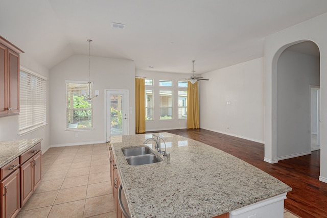 kitchen featuring light hardwood / wood-style flooring, sink, decorative light fixtures, a kitchen island with sink, and ceiling fan with notable chandelier